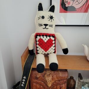 Hand crocheted cat plush toy with red heart